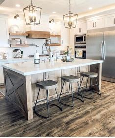 a kitchen island with three stools next to it