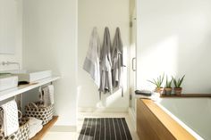 a bathroom with towels hanging on the wall next to a bathtub and sink area