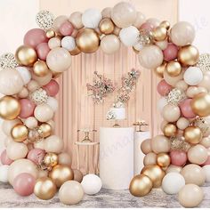 the balloon arch is decorated with gold, white and pink balloons