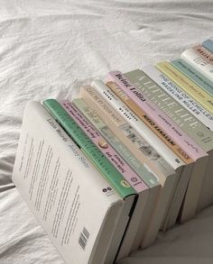 a stack of books sitting on top of a bed