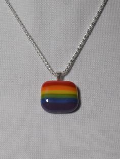 "This is a Pride rainbow glass pendant. This would make a wonderful gift to let someone know you love them for who they are. The glass is opaque so it stands out against dark colors. The necklace is a 20\" sterling silver 1.6 mm wheat style chain. The bail is also sterling silver, and is in a heart shape. The necklace can be reversible if you want to show the heart. I gladly accept returns and exchanges. Contact me within 7 days of delivery. Ship item(s) back within 14 days of delivery. Please c Pride Jewelry Necklaces, Rainbow Heart Pendant Necklace, Multicolor Recycled Glass Beads For Jewelry Making, Multicolor Recycled Glass Jewelry For Jewelry Making, Adjustable Rainbow Glass Necklaces, Adjustable Rainbow Glass Necklace, Rainbow Glass Jewelry Gift, Rainbow Glass Jewelry For Gifts, Handmade Multicolor Recycled Glass Jewelry