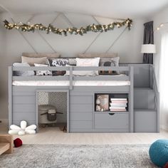 there is a loft bed with stairs in the middle and storage under it for toys