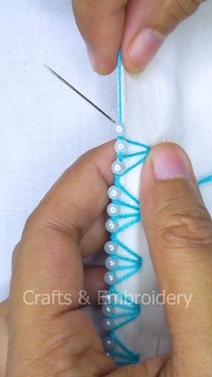 someone is working on something that looks like string and beading with scissors in their hands