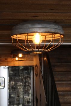 a light that is sitting on top of a metal fixture in a room with wooden walls