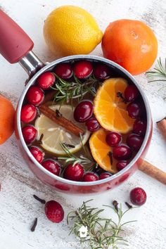 a pot filled with oranges, cranberries and spices