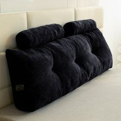 a black pillow sitting on top of a white couch