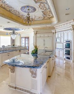 a large kitchen with marble counter tops and an ornate design on the ceiling above it