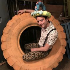 a man sitting on top of a giant tire