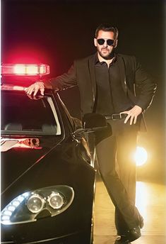 a man standing next to a black car