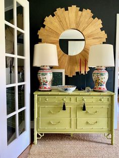 a green dresser with two lamps and a mirror