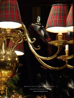 a gold chandelier with red and white plaid lamps