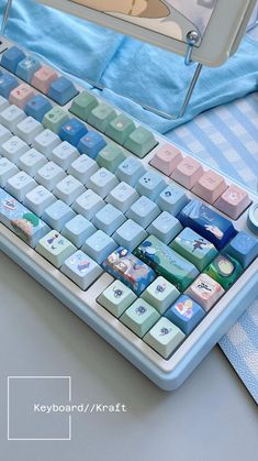 a computer keyboard sitting on top of a blue and white cloth covered table next to a mouse