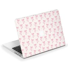 an open laptop computer with pink bows on the cover and white background, which is also used as a skin for the apple macbook pro