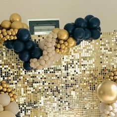 some balloons are hanging on the wall in front of gold and black tiles with white balls