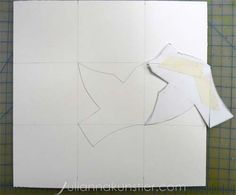 cut out pieces of paper sitting on top of a cutting mat