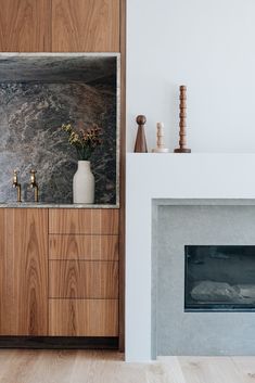 there is a fireplace in the living room with wood and marble decorations on it's mantle