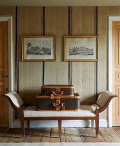 an old trunk is sitting on a bench in front of two framed pictures and paintings