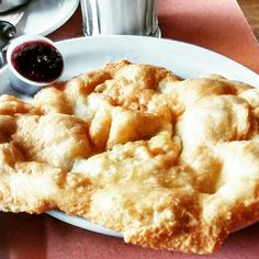 a white plate topped with an apple pie next to a cup of coffee and silverware