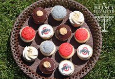 cupcakes are arranged on a tray in the grass