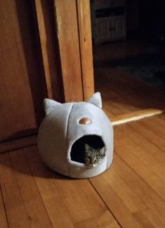 a cat is laying in its bed on the floor