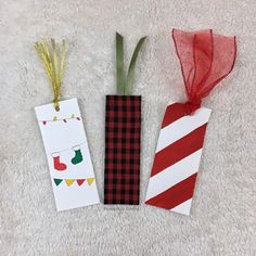 two paper tags with christmas decorations on them sitting next to each other in the shape of candy canes