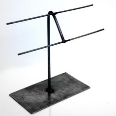 a metal stand with two black bars on it's top and one is upside down