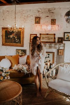 a woman standing in a living room next to a couch