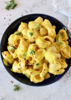 a black bowl filled with macaroni and cheese