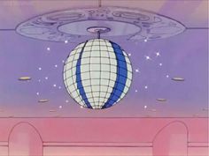 a large white and blue ball suspended from the ceiling in a room with pink walls