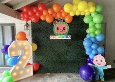 balloons and decorations are displayed in front of a wall with the number two on it