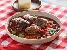 a bowl of meatballs in tomato sauce on a red and white checkered tablecloth