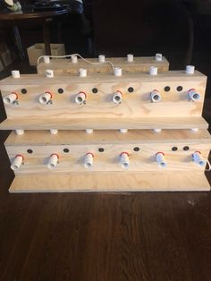 three wooden pegs are stacked on top of each other to make an instrument stand