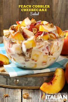 peach cobbler cheesecake salad in a glass bowl on top of a wooden table