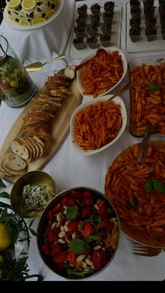 a table topped with lots of plates and bowls filled with different types of food next to each other