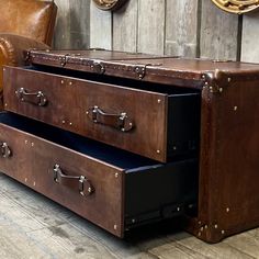 two brown leather chests sitting on top of a wooden floor