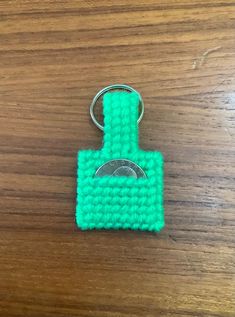 a crocheted keychain with a ring attached to it on a wooden surface