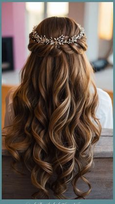 the back of a woman's head with long wavy hair and a tiara