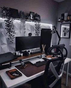 a desk with a computer monitor, keyboard and mouse on it in front of a wall