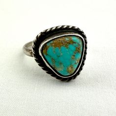 This vintage Native American ring is made of hand wrought Sterling silver. The center turquoise stone is a beautiful blue color with a golden brown matrix. It is bezel set and surrounded by handmade rope detailing.  The center setting measures 5/8" x just over 1/2" at its widest points. The ring is a size 5. The total weight is 3 grams. There are no hallmarks but I did test it to ensure that it is made of sterling silver.  Great vintage condition! Native American Turquoise Ring, Native American Rings, Native American Turquoise, American Turquoise, Golden Brown, Turquoise Stone, Rings Statement, Beautiful Blue, Matrix