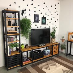 a living room with black and white triangles painted on the wall, shelves holding various items