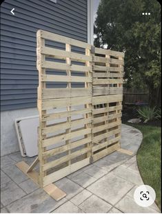 a fence made out of wooden pallets in front of a house