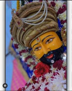 a yellow mask sitting on top of flowers