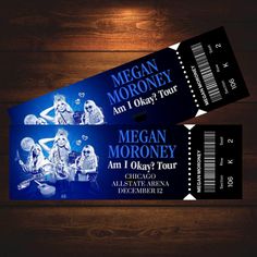 two concert tickets sitting on top of a wooden table