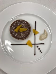 a white plate topped with a dessert on top of a table next to a knife and fork