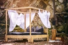 a bed made out of wood and white sheets