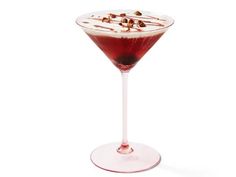 a drink in a wine glass with nuts on the rim