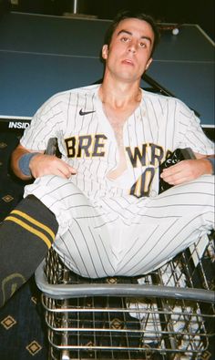 a baseball player sitting in a shopping cart