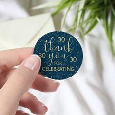 a hand holding a sticker that says 30 thank you for celebrating