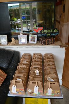 boxes are lined up on a table in front of a store window with tags attached to them