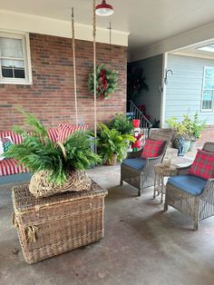 the front porch is decorated for christmas with wicker furniture